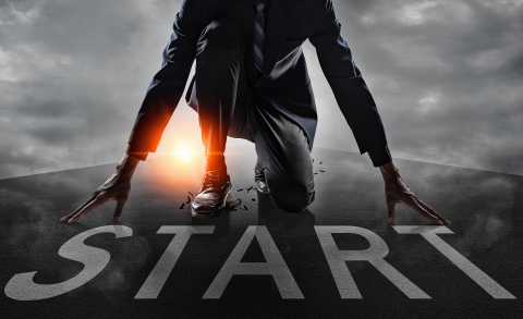 Personne en tenue professionnelle en position de départ sur une piste de course avec le mot « START » inscrit au sol.